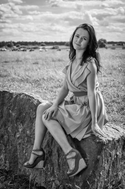 taş üzerine oturan esmer kadın