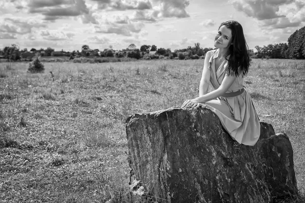 Brunette vrouw zitten op steen — Stockfoto