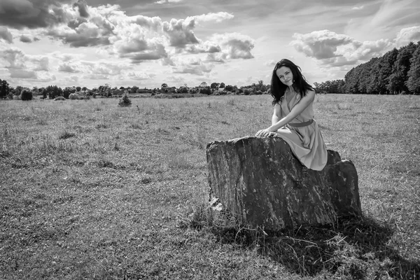Morena mulher sentada na pedra — Fotografia de Stock