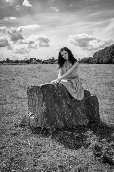 Bruna donna seduta sulla pietra — Foto Stock