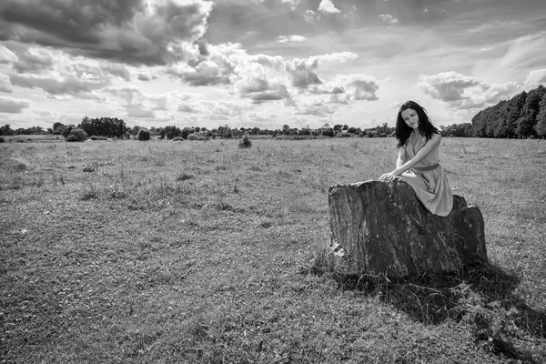 Brunette  woman  sitting on stone — Stock Photo, Image