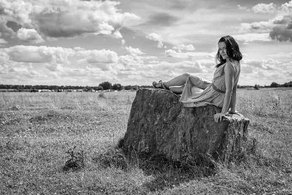 Brunett kvinna sitter på sten — Stockfoto