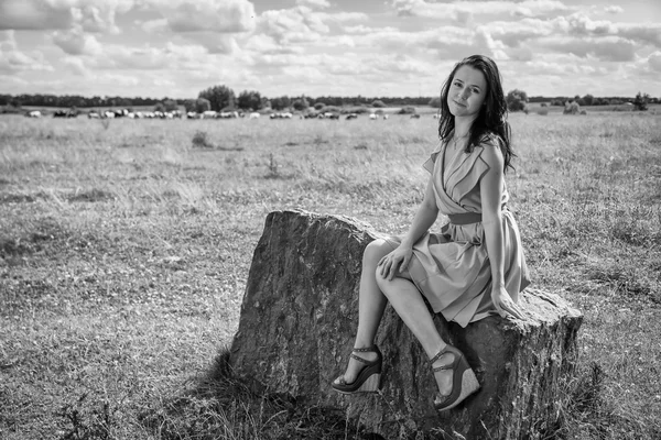 Brunette  woman  sitting on stone — Stock Photo, Image