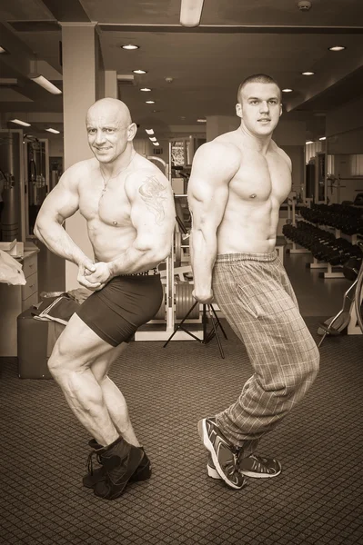Two bodybuilders demonstrating muscles — Stock Photo, Image