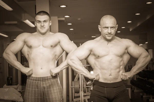 Två bodybuilders visar musklerna — Stockfoto