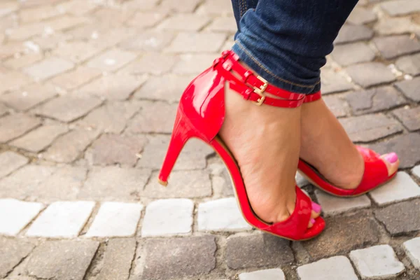 Γυναίκα πόδια σε κόκκινα ψηλοτάκουνα παπούτσια — Φωτογραφία Αρχείου