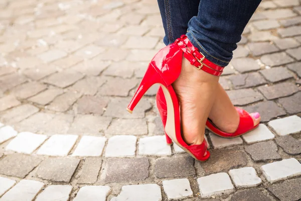 Piernas de mujer en zapatos rojos de tacón alto — Foto de Stock