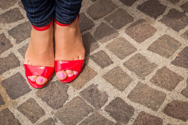 Piernas de mujer en zapatos rojos de tacón alto — Foto de Stock