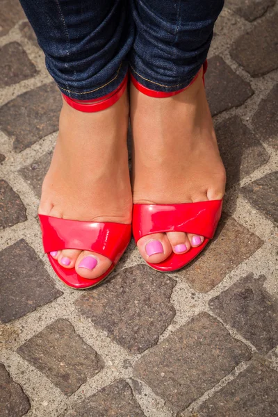 Piernas de mujer en zapatos rojos de tacón alto — Foto de Stock