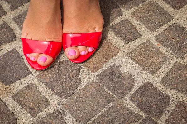 Piernas de mujer en zapatos rojos de tacón alto — Foto de Stock