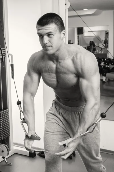 Man makes exercises at  gym — Stock Photo, Image