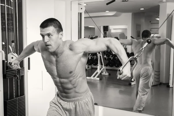 Man makes exercises at  gym — Stock Photo, Image