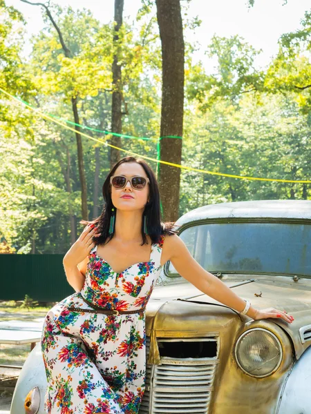 Morena mujer cerca de coche vintage — Foto de Stock