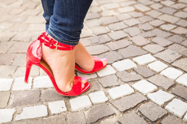 Piernas de mujer en zapatos rojos de tacón alto — Foto de Stock