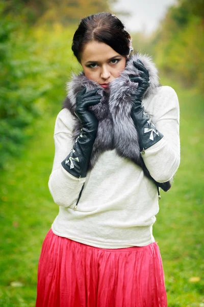 Девушка позирует на улице в меховом шарфе — стоковое фото