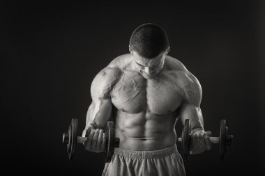 adam dumbbells ile çalışmaları yapan.