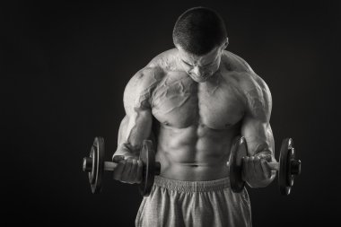 adam dumbbells ile çalışmaları yapan.