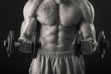 adam dumbbells ile çalışmaları yapan.