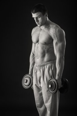 adam dumbbells ile çalışmaları yapan.