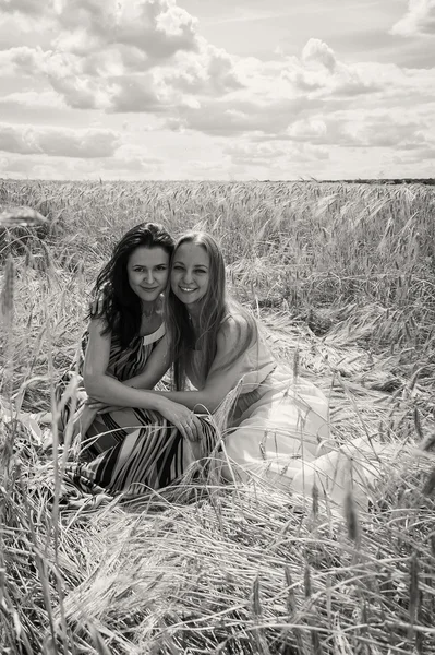 Girls standing in a wheat field. — Stock Photo, Image