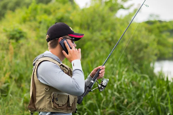 Pescatore che chiama con un cellulare — Foto Stock