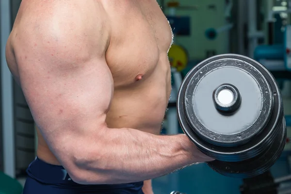 Man makes exercises with dumbbells. — Stock Photo, Image