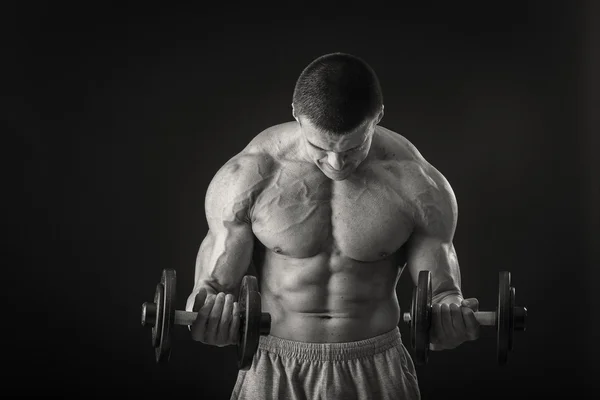 Adam dumbbells ile çalışmaları yapan. — Stok fotoğraf