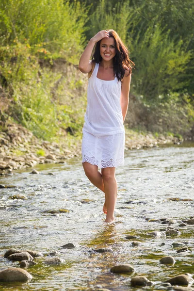 Femme marchant sur la rivière de montagne rapide — Photo