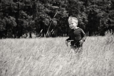 Küçük çocuk bir sahada çalışan