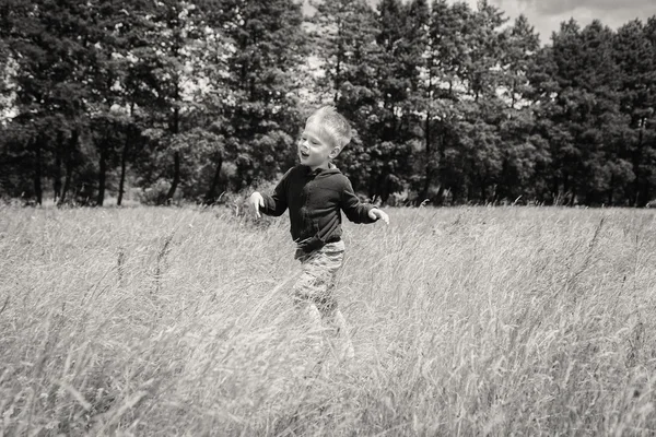 Μικρό αγόρι τρέχει σε ένα πεδίο — Φωτογραφία Αρχείου