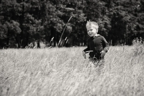 Jongetje wordt uitgevoerd op een veld — Stockfoto