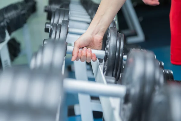 Muscular arm holding dumbbell — Stock Photo, Image