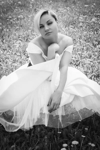 Blondynka w białej sukni w wiosenny ogród — Zdjęcie stockowe