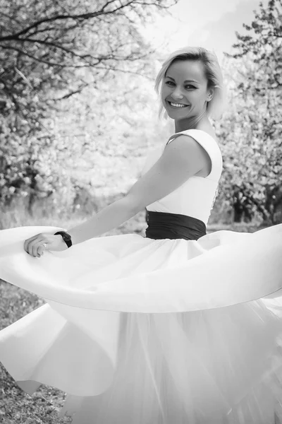 Blondine im weißen Kleid im Frühlingsgarten — Stockfoto