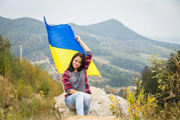 Kobieta na szczycie góry z flag ukraińskich — Zdjęcie stockowe