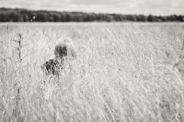 Chlapec stál ve vysoké trávě — Stock fotografie