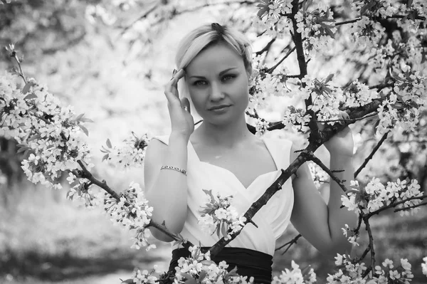 Rubia en vestido blanco en jardín de primavera —  Fotos de Stock