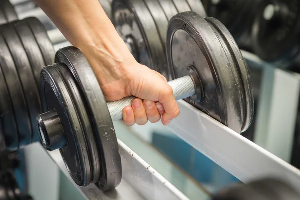 Hand holding a dumbbell in gym — Stock Photo, Image