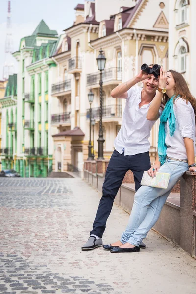 Couple with map and binocular on street — Stock Photo, Image