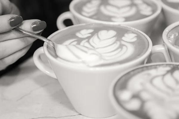 Ruka drží lžíci s pěnu cappuccino — Stock fotografie
