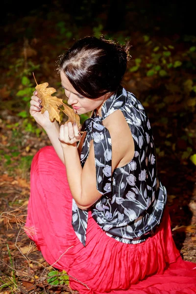 Mujer vestida de rojo en el parque de otoño — Foto de Stock