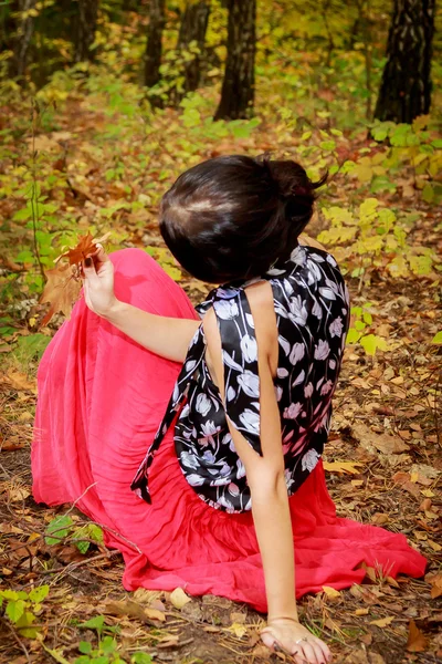 Frau in rotem Kleid im Herbstpark — Stockfoto