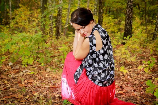 Donna in abito rosso nel parco autunnale — Foto Stock