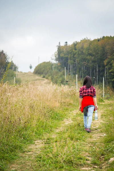 Mädchen in legerer Kleidung klettert bergauf — Stockfoto