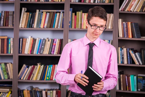 Student hält Buch in der Bibliothek — Stockfoto