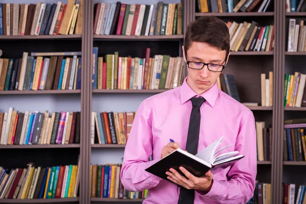 Student holding book at library — Stock Photo, Image