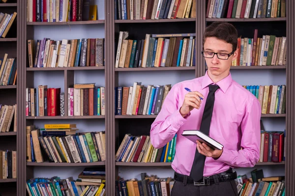 Student hält Buch in der Bibliothek — Stockfoto