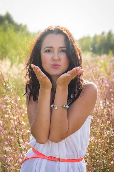 Flicka i vit klänning stående i högt gräs — Stockfoto