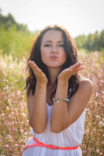 Chica en vestido blanco de pie en la hierba alta — Foto de Stock