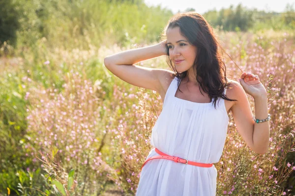 Chica en vestido blanco de pie en la hierba alta — Foto de Stock